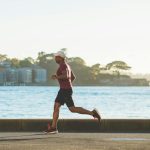 Runner che corre all'aperto, simbolo di benefici del running e dell'importanza di alimentazione e idratazione