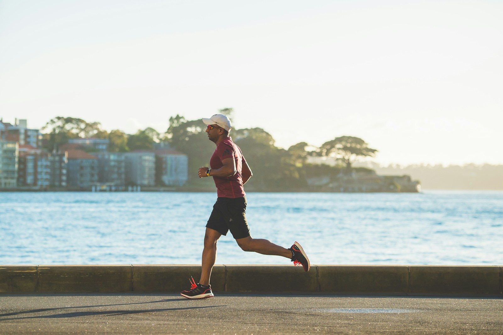 Runner che corre all'aperto, simbolo di benefici del running e dell'importanza di alimentazione e idratazione