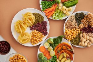 Alimenti ricchi di fibre con legumi, verdure, cereali, semi e frutta secca.