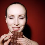 Donna con una tavoletta di cioccolato tra le mani