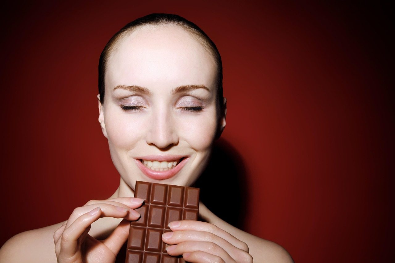 Donna con una tavoletta di cioccolato tra le mani