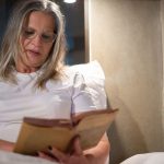 Donna che legge a letto prima di dormire