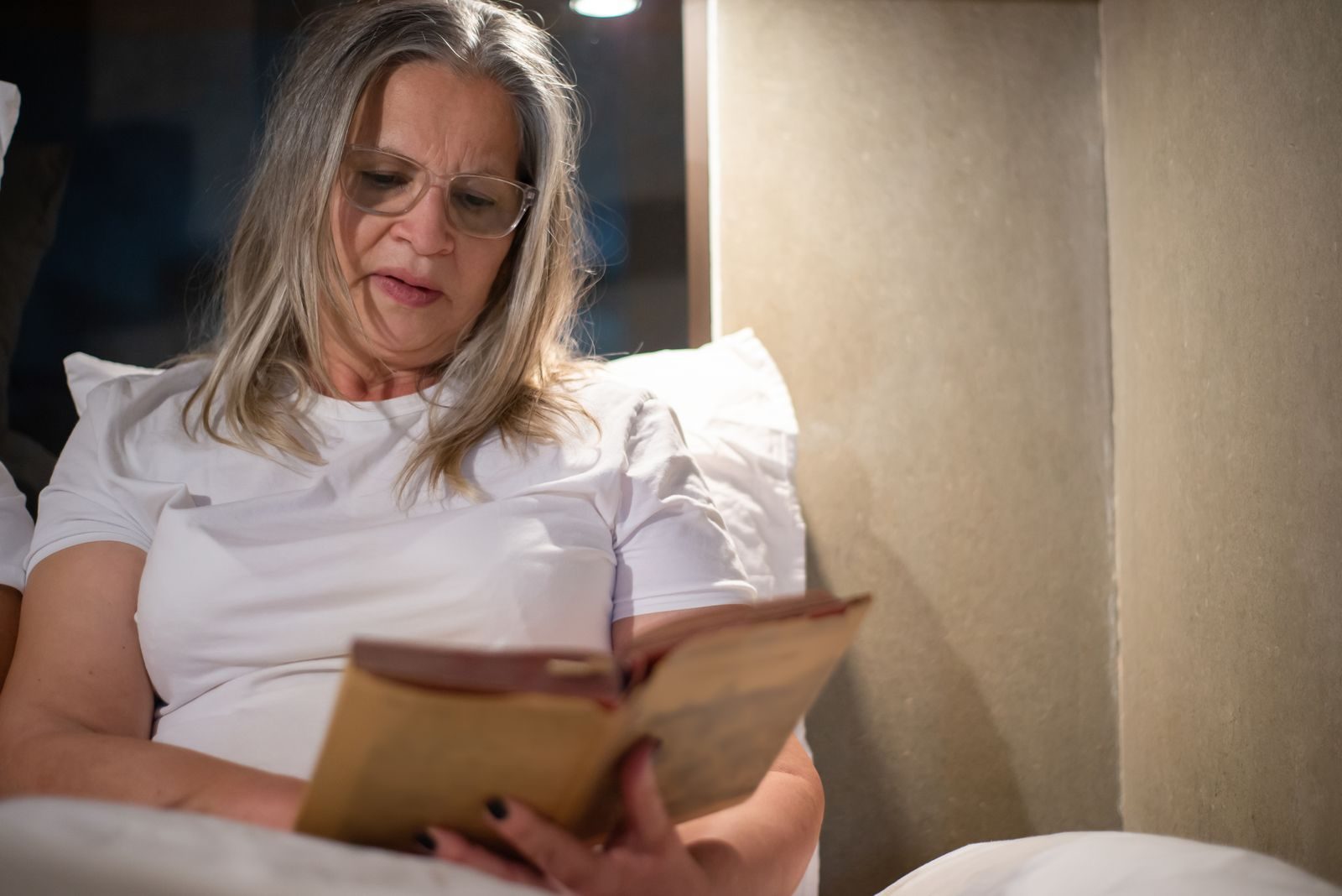 Donna che legge a letto prima di dormire