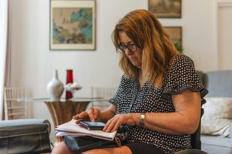 Donna in menopausa controlla gli impegni su telefono e sugli appunti