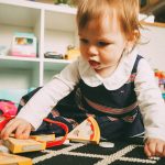 Bambina che gioca sul pavimento