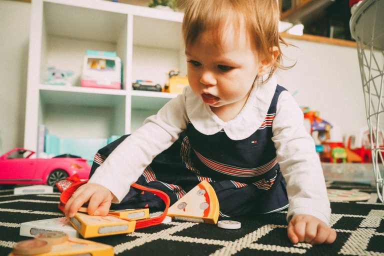 Bambina che gioca sul pavimento