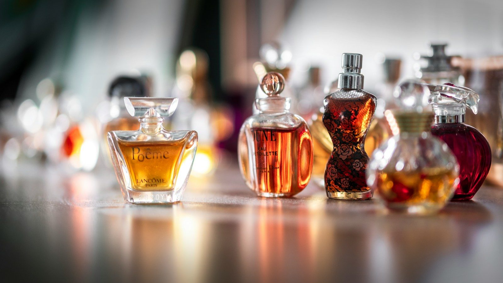 Flaconi di profumo di diverse forme e colori disposti su una superficie